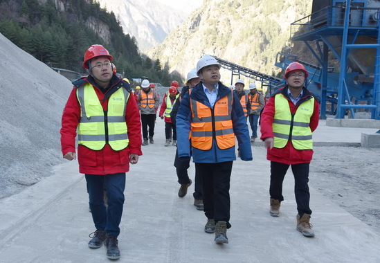 王建峰（左）陪同何林（中）察看现场建设情况.jpg